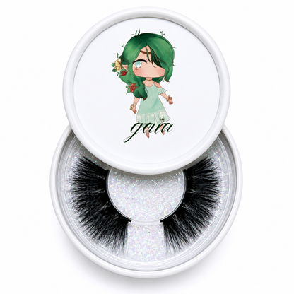 Gaia false eyelashes in a clear round case beside an illustrated character lid on a white background