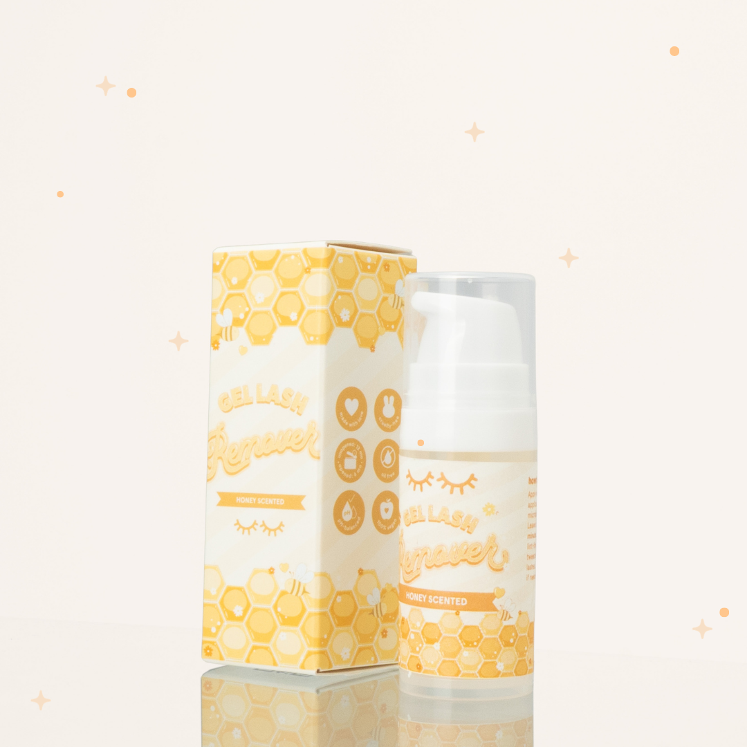 Honey scented gel lash remover beside its yellow and white packaging with honeycomb illustrations on it.