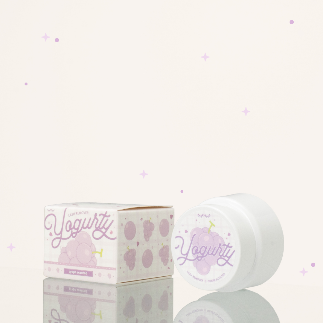Side view of Grape scented yogurty lash remover beside its purple-and-white packaging.