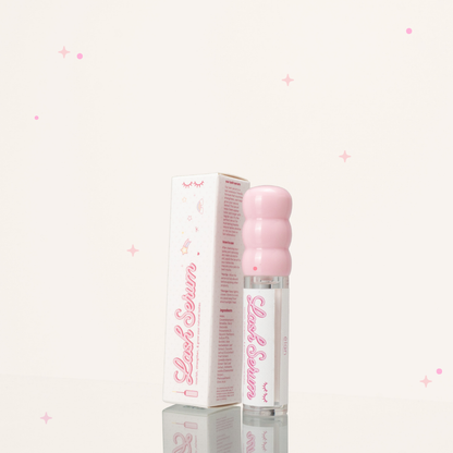 Side view of eyelash growth serum in a clear and pink tube beside its pink-and-white packaging.