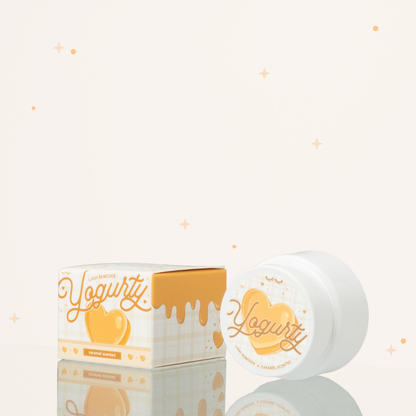 Side view of Caramel scented yogurty lash remover beside its brownish-orange-and-white packaging.