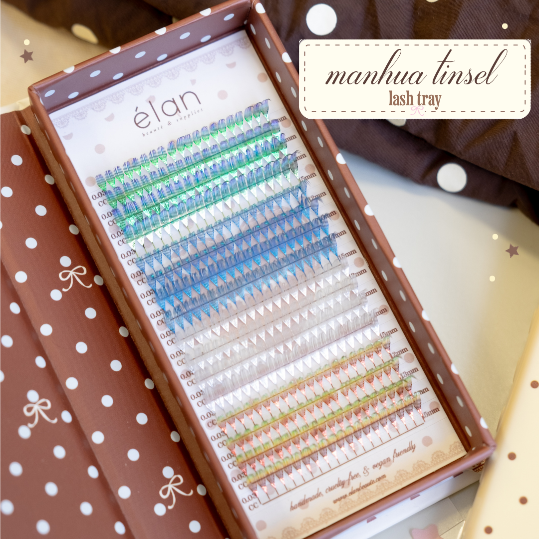 Inside of Manhua Tinsel Lash Tray with green, blue, white, and yellow-orange lashes in its brown polka dot packaging.