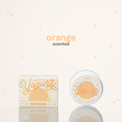 Orange scented yogurty lash remover beside its orange-and-white packaging.