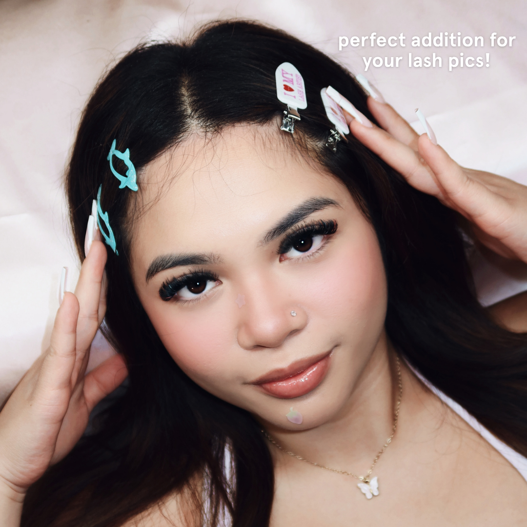 Person wearing crease-free hair clips with white and pink polka dots and text on it saying "I Heart My Lash Artist" in pink text.