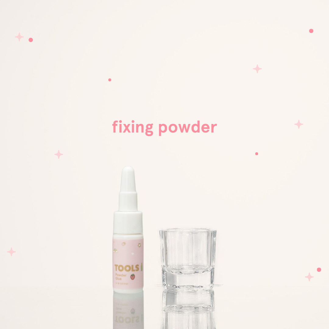 Fixing powder in its pink and white packaging with text saying "Fixing Powder" next to a small glass cup.