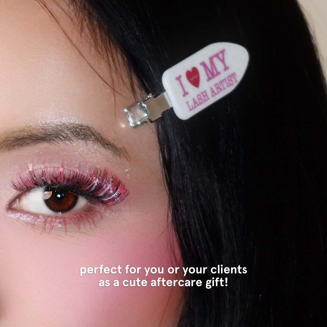 Person wearing crease-free hair clips with white and pink polka dots and text on it saying "I Heart My Lash Artist" in pink text.