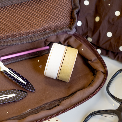 Sensitive Lash Tape in white and beige with a brown bag, hair clips, and glasses next to it.