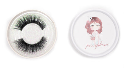 Persephone false eyelashes in a clear round case beside the illustrated Persephone product lid on a white background.