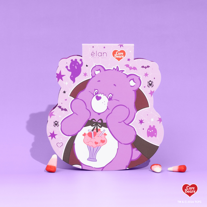 Élan Beauté x Care Bears Share Bear purple Big Boi lash tray in purple Halloween-themed Care Bears packaging with candy corn accents.