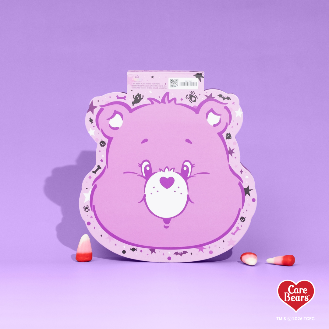 Élan Beauté x Care Bears Share Bear purple Big Boi lash tray in purple Halloween-themed Care Bears packaging with candy corn accents.