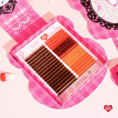 Élan Beauté x Care Bears Cheer Bear red Big Boi lash tray featuring warm brown and red lashes in pink Halloween-themed Care Bears packaging.