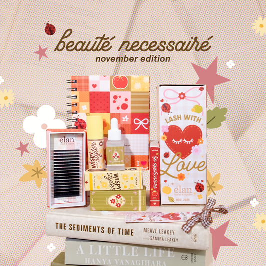 Élan Beauté November Beauté Necessaire featuring a book-themed lash collection with Comic Lashes, Wispy Styler, protein remover, client book, bookmark, and matching “Lash With Love” packaging styled on stacked books.