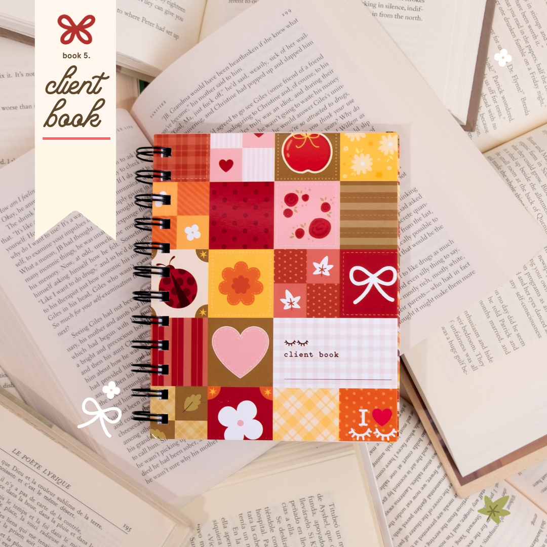 Book-themed client book with a colorful patchwork cover featuring hearts, flowers, bows, ladybugs, and warm red, orange, pink, and yellow tones, styled on top of open book pages.