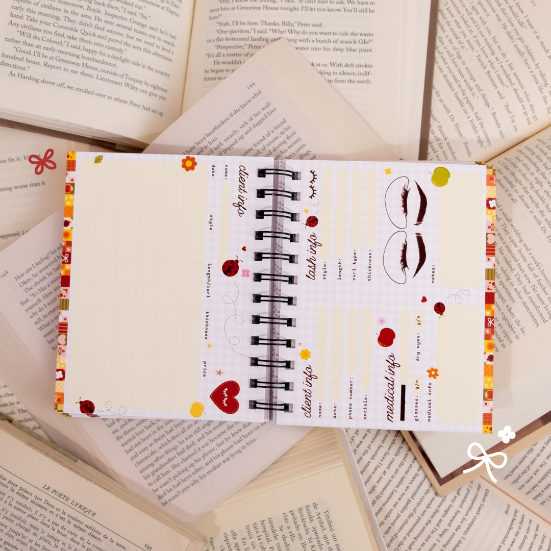 Open spiral-bound lash client book showing client information, medical details, lash mapping sections, and note areas, styled on top of open book pages with colorful floral and ladybug accents.