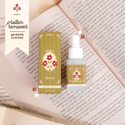 Gardenia-scented protein remover in olive green floral packaging with a matching dropper bottle, styled on top of open book pages.
