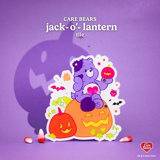 Élan Beauté x Care Bears Jack-o’-Lantern lash tile featuring a purple Care Bear sitting on orange pumpkins, surrounded by ghosts, bats, stars, and candy corn on a purple Halloween background.