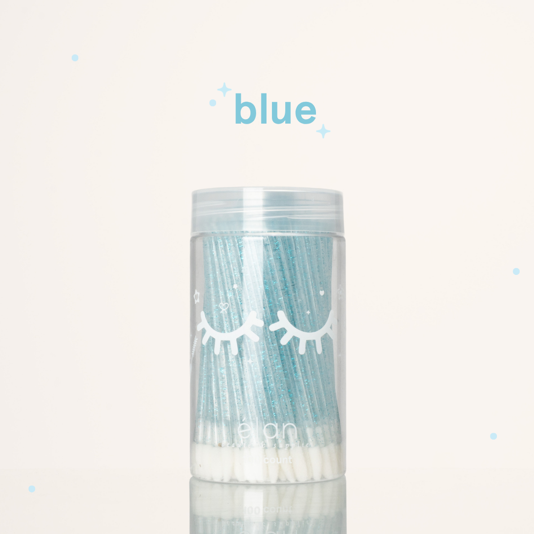 Élan Beauté blue glitter lash applicator brushes in a clear 100-count container with white eyelash graphics, displayed on a soft cream background with blue accents.