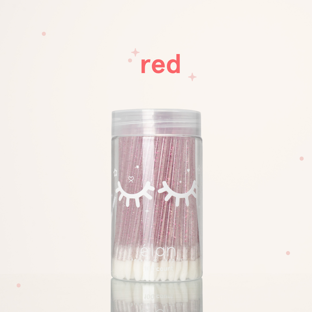 Élan Beauté red glitter lash applicator brushes in a clear 100-count container with white eyelash graphics, displayed on a soft cream background with red accents.