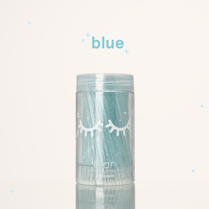 Élan Beauté blue glitter microbrush applicator brushes in a clear 100-count container with white eyelash graphics, displayed on a soft cream background with blue accents.