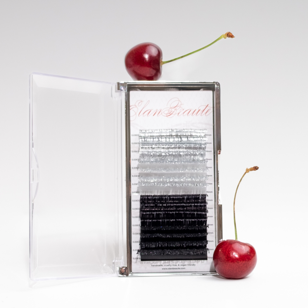 Silver tinsel, glitter, and black lash tray in 0.03 CC curl, displayed in a clear case with red cherries on a white background.