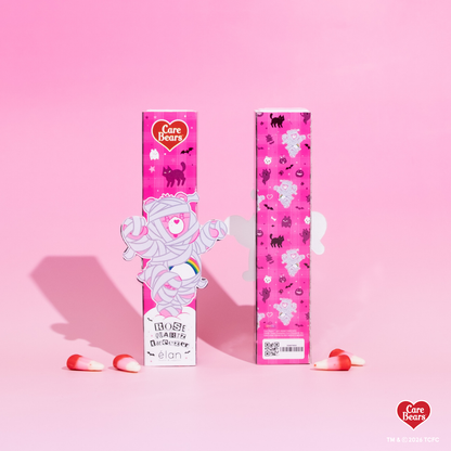 Élan Beauté x Care Bears Rose Quartz tweezer packaging featuring Pink Care Bear dressed as a mummy with pink Halloween-themed graphics and candy corn accents.