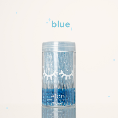 Élan Beauté blue glitter spoolies in a clear 100-count container with white eyelash graphics, displayed on a soft cream background with blue accents.