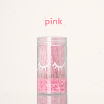Élan Beauté pink glitter spoolies in a clear 100-count container with white eyelash graphics, displayed on a soft cream background with pink accents.