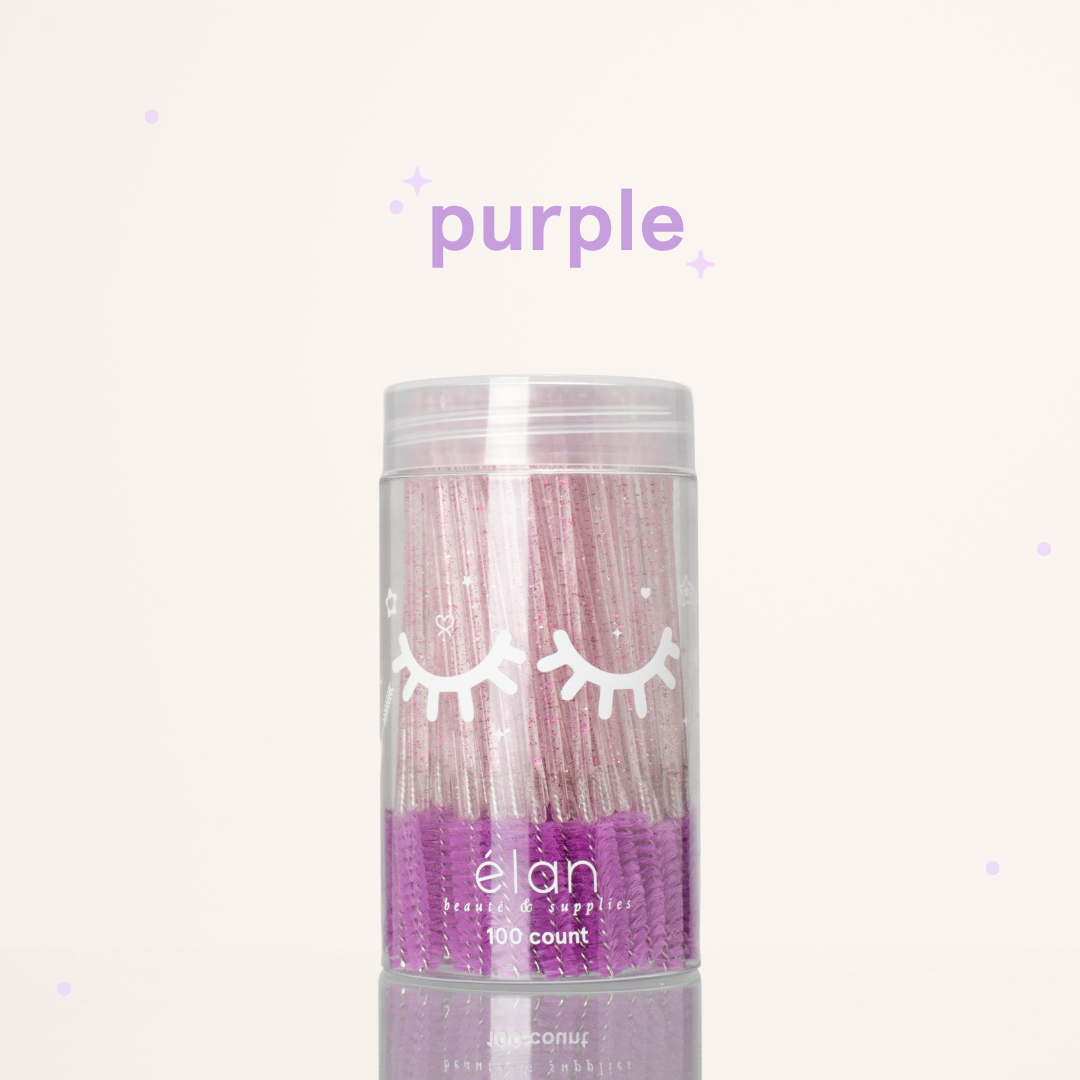 Élan Beauté purple glitter spoolies in a clear 100-count container with white eyelash graphics, displayed on a soft cream background with purple accents.