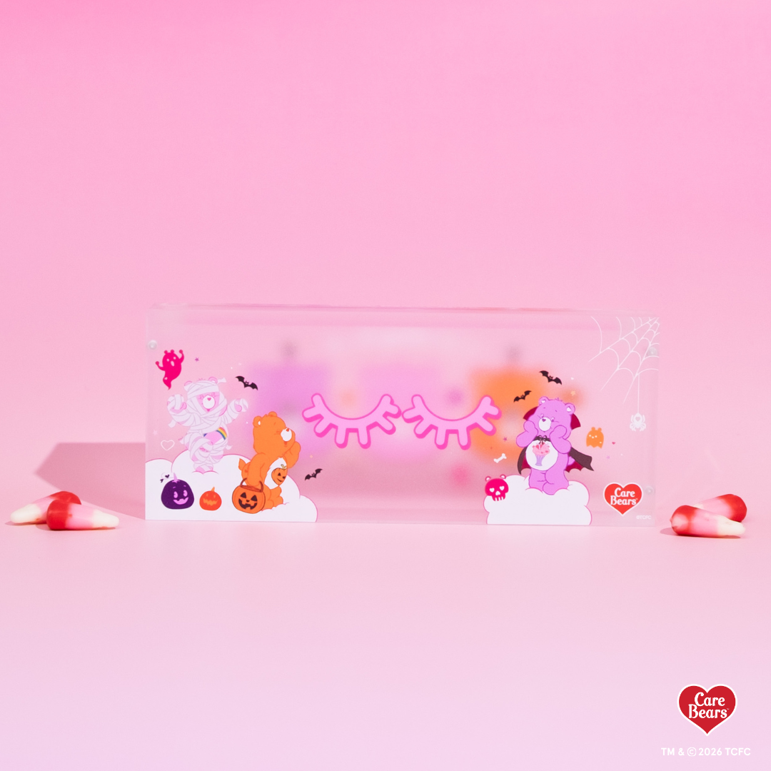 Élan Beauté x Care Bears Halloween magnetic tweezer case featuring pink, orange, and purple Care Bears character artwork with bats, pumpkins, spiderweb details, and candy corn accents.